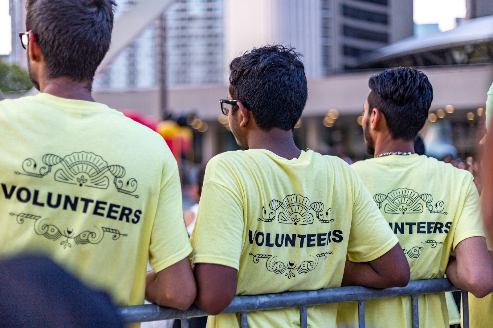 Three event volunteers in matching yellow printed t-shirts