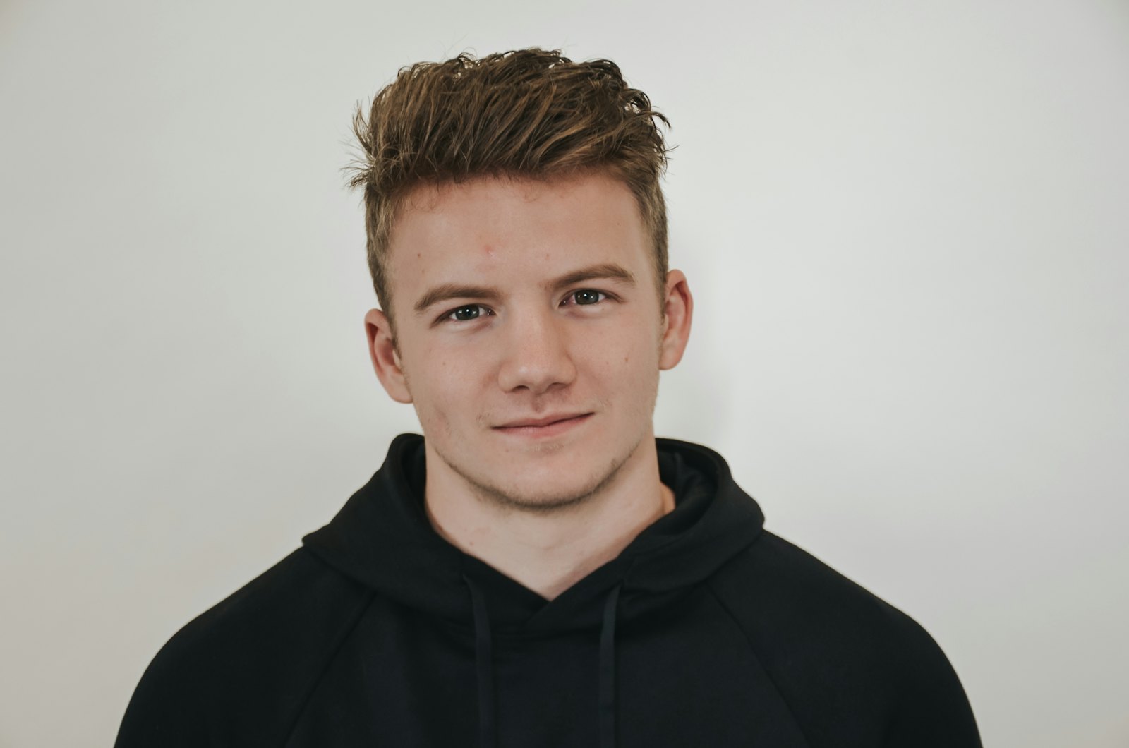 Man wearing a plain black pullover hoodie
