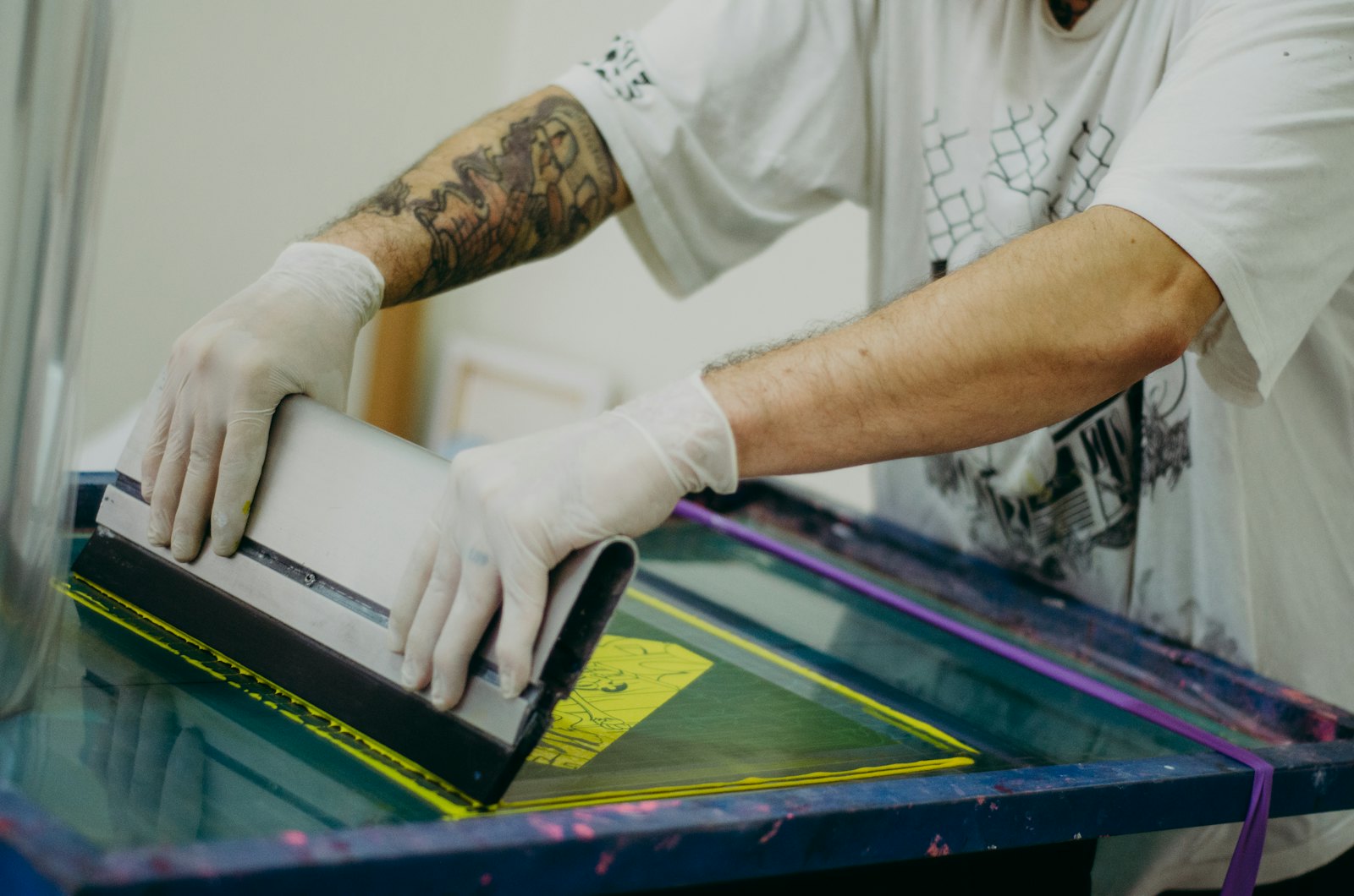 A printer pulling ink across a screen with a squeegee