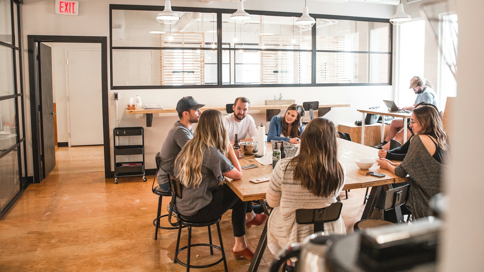 A startup team talking around a wooden table in a bright office