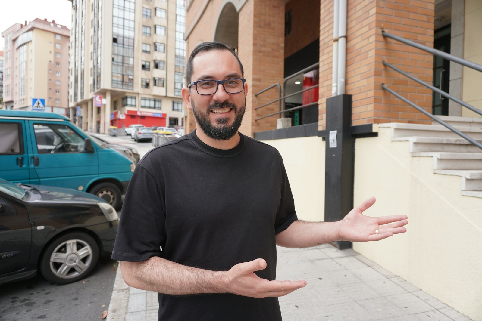 Man in a plain black t-shirt on a city street